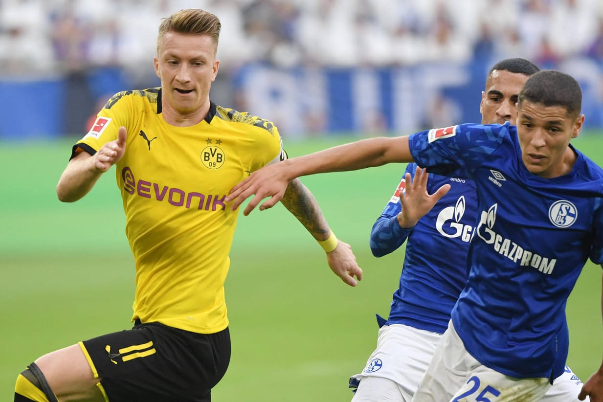 Marco Reus (l.) im Zweikampf mit den Schalkern Mascarell (m.) und Harit: Das Revierderby steht dieses Jahr unter besonderen Vorzeichen.
