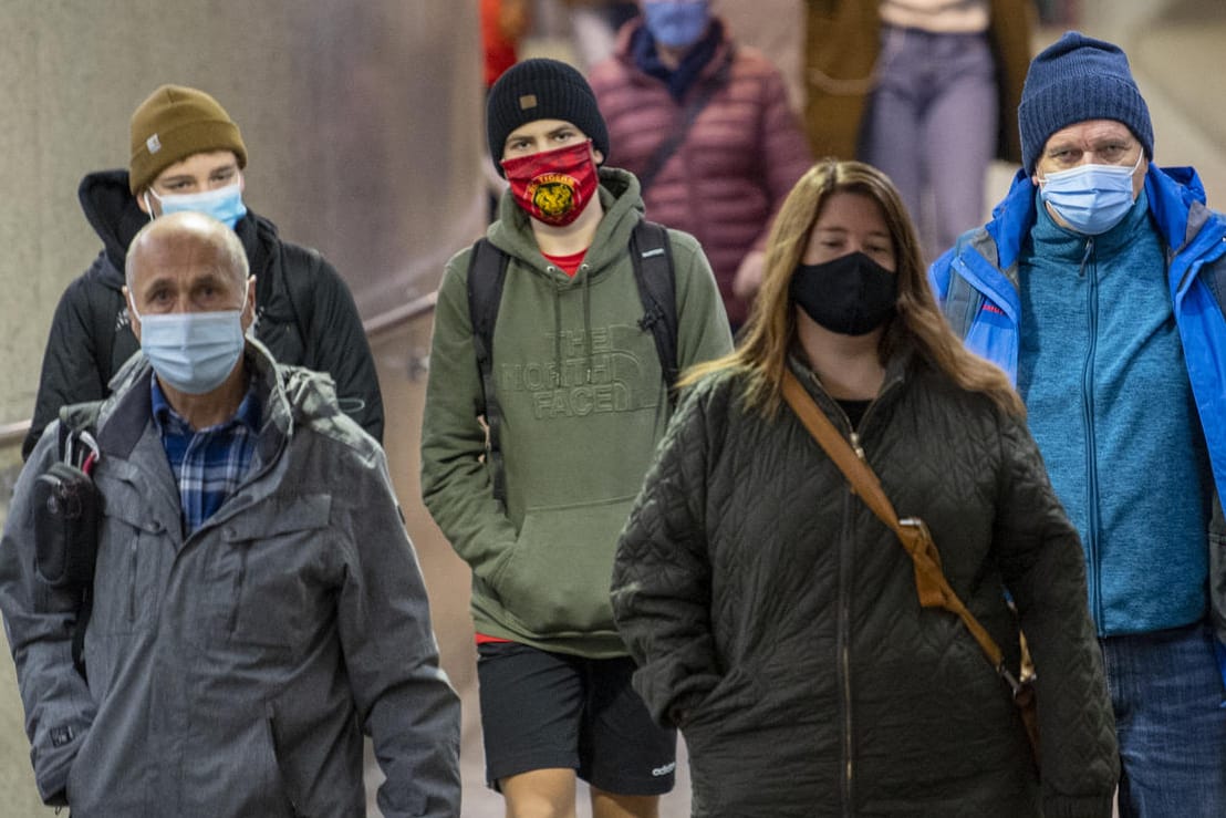 Passanten tragen auf einem Bahnhof Masken: Ärtzekammerpräsident Reinhardt hat die Wirksamkeit von Masken angezweifelt.