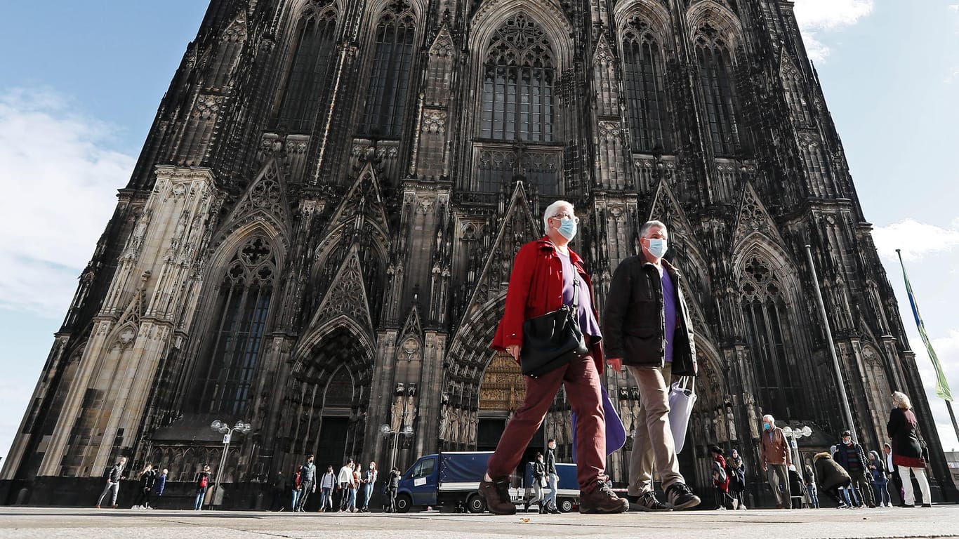 Menschen mit Masken vor dem Kölner Dom: Die Corona-Infektionszahlen sind in Deutschland in den letzten Tagen sprunghaft angestiegen.