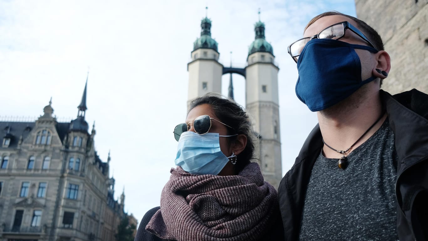 Passanten tragen auf dem Marktplatz in Halle Mund- und Nasenschutz: In der Innenstadt von Halle gilt eine Maskenpflicht.