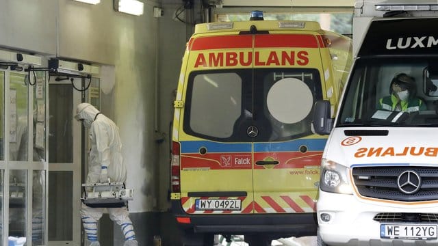 Ein Mann mit Schutzkleidung geht in Warschau in ein auf Corona-Fälle spezialisiertes Krankenhaus. Ein Mann mit Schutzkleidung geht in Warschau in ein auf Corona-Fälle spezialisiertes Krankenhaus.