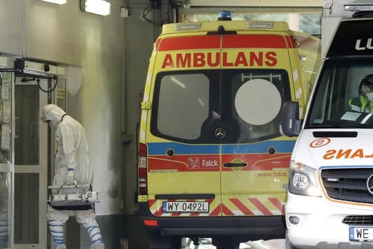 Ein Mann mit Schutzkleidung geht in Warschau in ein auf Corona-Fälle spezialisiertes Krankenhaus.