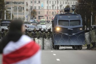 Ein Demonstrant steht in Minsk einer Reihe von Polizisten gegenüber.