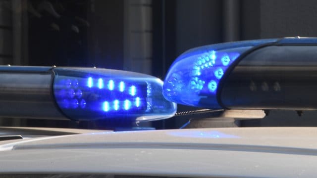 Polizeifahrzeuge stehen mit eingeschaltetem Blaulicht