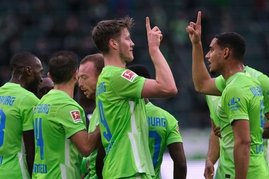 Wolfsburgs Wout Weghorst (M) bejubelt sein Tor zum 1:0 gegen Arminia Bielefeld mit Mannschaftskamerad Maxence Lacroix (r).