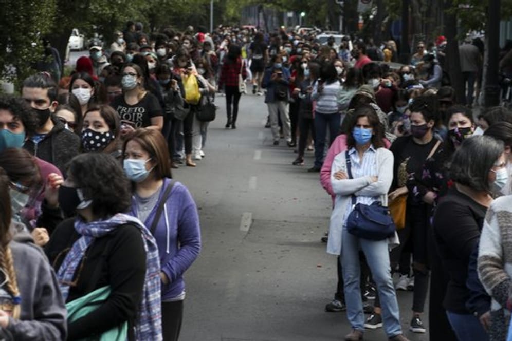 In langen Schlangen stehen die Menschen in Chiles Hauptstadt an, um ihre Stimmen abzugeben.