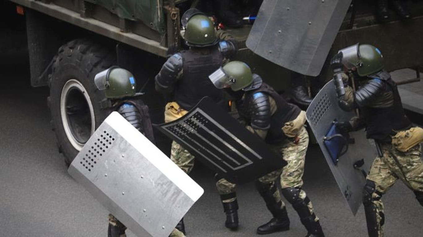 Polizisten verlassen am Rande der Protestaktionen in Minsk am Sonntag ihren Mannschaftswagen.