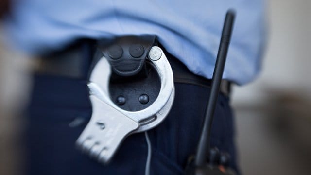 Handschellen am Gürtel eines Beamten: Polizeibeamte haben einen Mann festgenommen, der sie zuvor mit einer Waffe bedrohte. Handschellen am Gürtel eines Beamten: Polizeibeamte haben einen Mann festgenommen, der sie zuvor mit einer Waffe bedrohte.