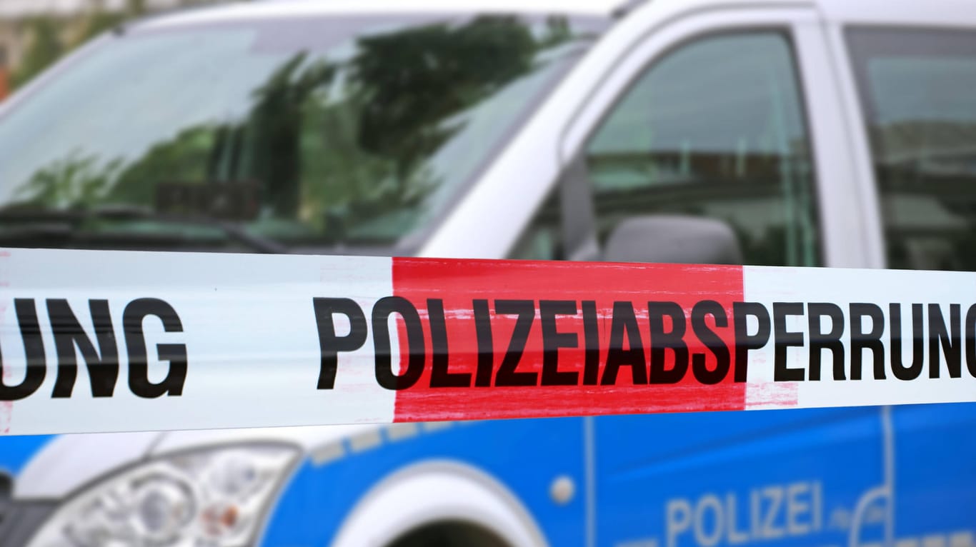 Polizeiabsperrung mit Polizeiauto im Hintergrund (Symbolbild): In Wuppertal ist ein Mann von drei Maskierten überfallen worden.