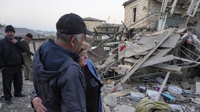 Ein Paar steht vor den Trümmern eines zerstörten Hauses in Berg-Karabach. Ein Paar steht vor den Trümmern eines zerstörten Hauses in Berg-Karabach.