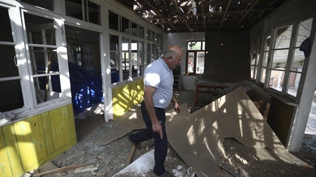 Nach Angriffen armenischer Truppen inspiziert ein Mann sein beschädigtes Haus im aserbaidschanischen Tartar. Nach Angriffen armenischer Truppen inspiziert ein Mann sein beschädigtes Haus im aserbaidschanischen Tartar.
