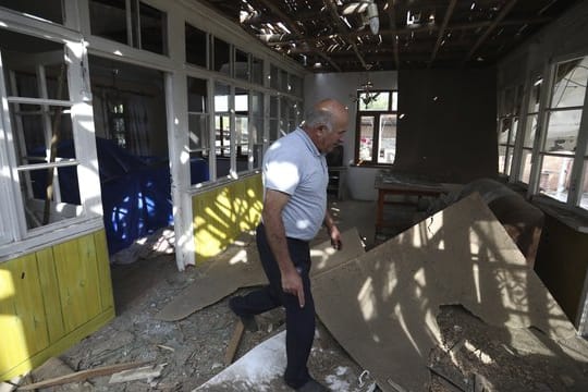 Nach Angriffen armenischer Truppen inspiziert ein Mann sein beschädigtes Haus im aserbaidschanischen Tartar.
