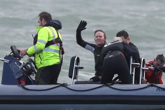 John Bream, ehemaliger Fallschirmspringer aus Großbritannien, winkt aus einem Boot, das ihn nach seinem Sprung aus etwa 40 Metern Höhe ins Meer geborgen hat.