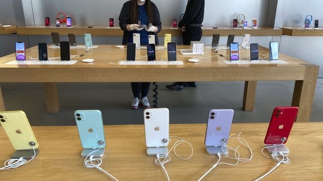 Mitarbeiter mit Mundschutz arbeitet in einem Apple Store in Peking. Mitarbeiter mit Mundschutz arbeitet in einem Apple Store in Peking.