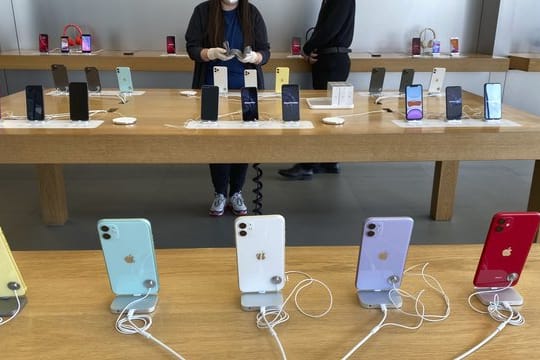 Mitarbeiter mit Mundschutz arbeitet in einem Apple Store in Peking.