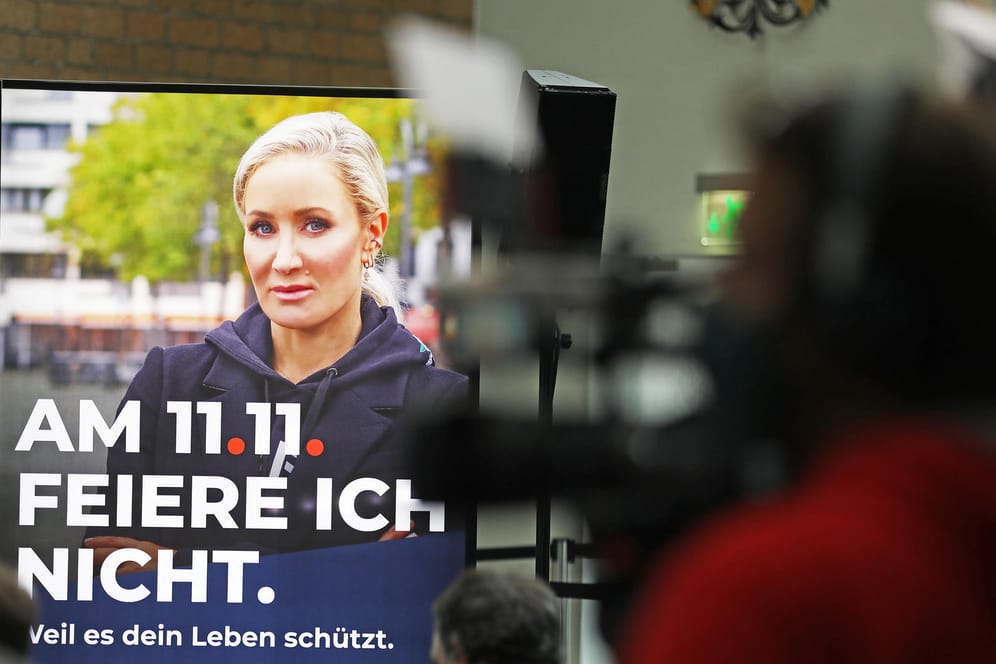 Hinter Kameraleuten ist ein Werbeplakat mit Schauspielerin und Moderatorin Janine Kunze und der Aufschrift: "Am 11.11. feiere ich nicht" zu sehen: Der Karnevalsauftakt in Köln muss dieses Jahr ausfallen.