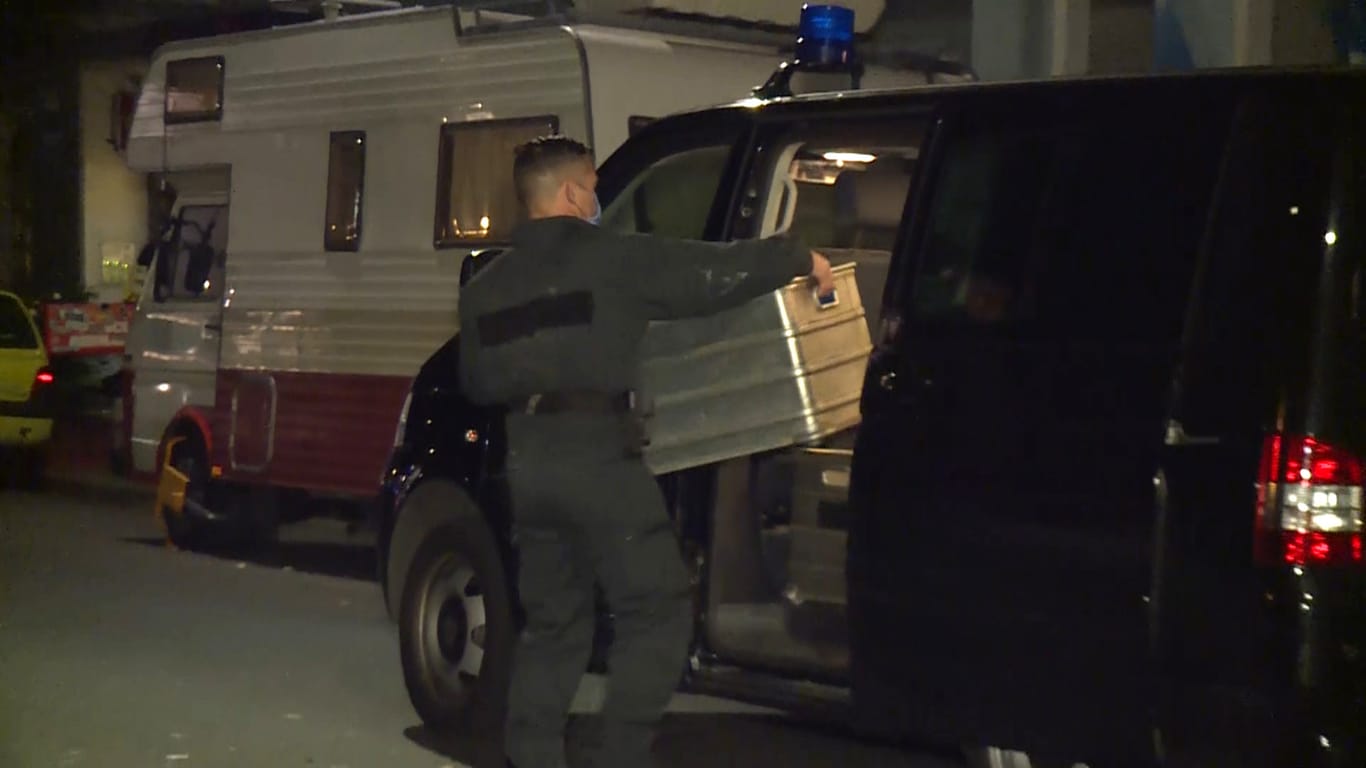 Ein Polizist packt eine Kiste in einen Lieferwagen: Durch Zufall hat die Polizei bei einer Wohnungsdurchsuchung einen explosiven Stoff gefunden.