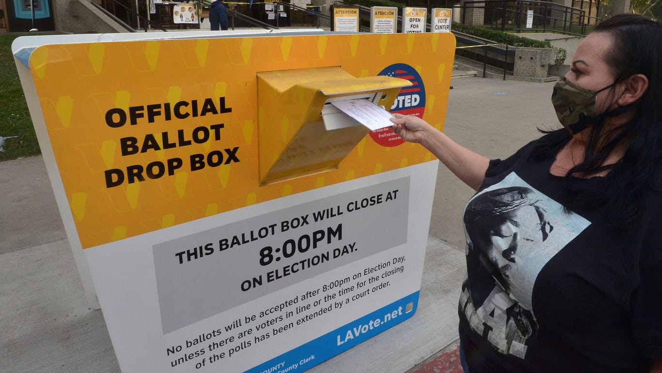 Eine US-Wählerin wirft einen Umschlag mit ihrem Stimmzettel im kalifornischen Norwalk in eine Briefwahl-Urne: Mehr als 46 Millionen ausgefüllte Stimmzettel sind bei den Wahlbehörden schon eingegangen.