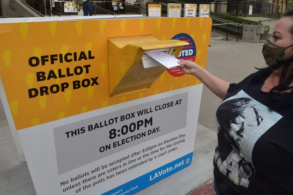 Eine US-Wählerin wirft einen Umschlag mit ihrem Stimmzettel im kalifornischen Norwalk in eine Briefwahl-Urne: Mehr als 46 Millionen ausgefüllte Stimmzettel sind bei den Wahlbehörden schon eingegangen.