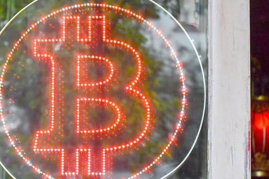 Ein Bitcoin-Logo in einem Schaufenster einer Kneipe im Kreuzberger Graefekiez.