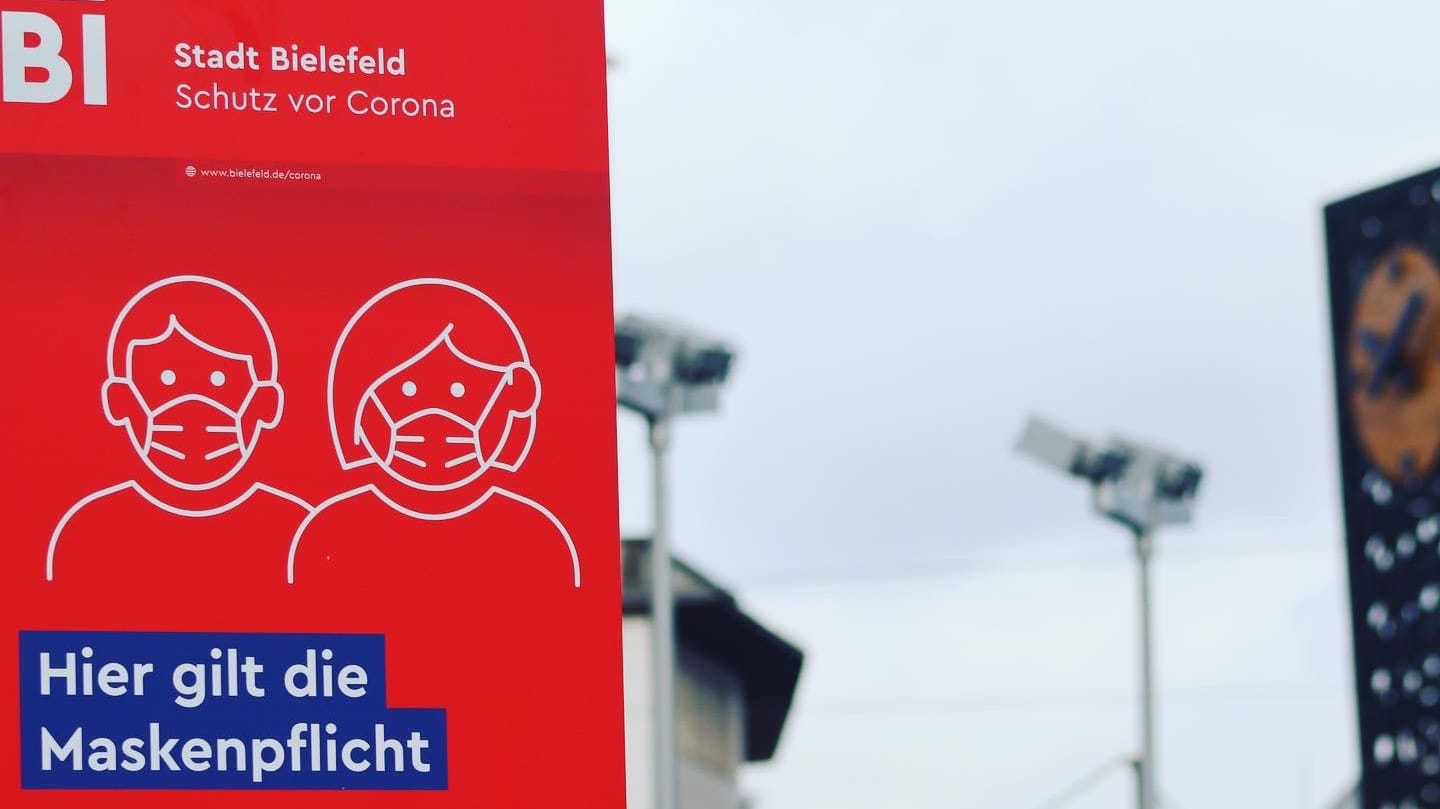Ein Schild am Jahnplatz in Bielefeld weist auf die geltende Maskenpflicht hin: Wegen der Corona-Pandemie ist diese Maßnahme erlassen worden.