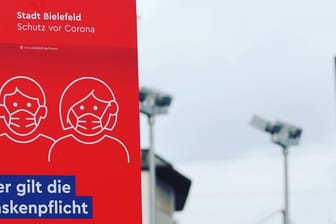 Ein Schild am Jahnplatz in Bielefeld weist auf die geltende Maskenpflicht hin: Wegen der Corona-Pandemie ist diese Maßnahme erlassen worden.