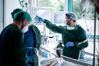 Mitarbeiter der Pflege in Schutzkleidung behandeln einen Corona-Patienten: Das Virus breitet sich weiter in Deutschland aus.