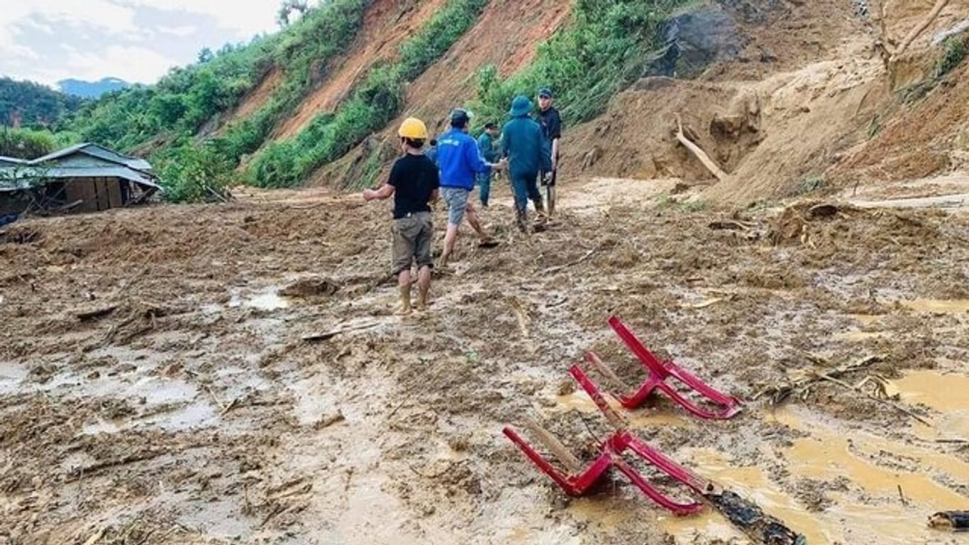 Dorfbewohner waten durch Schlamm, nachdem ein Erdrutsch ein Dorf im ländlichen Bezirk Phuoc Loc in der Provinz Quang Nam überschwemmt hat.