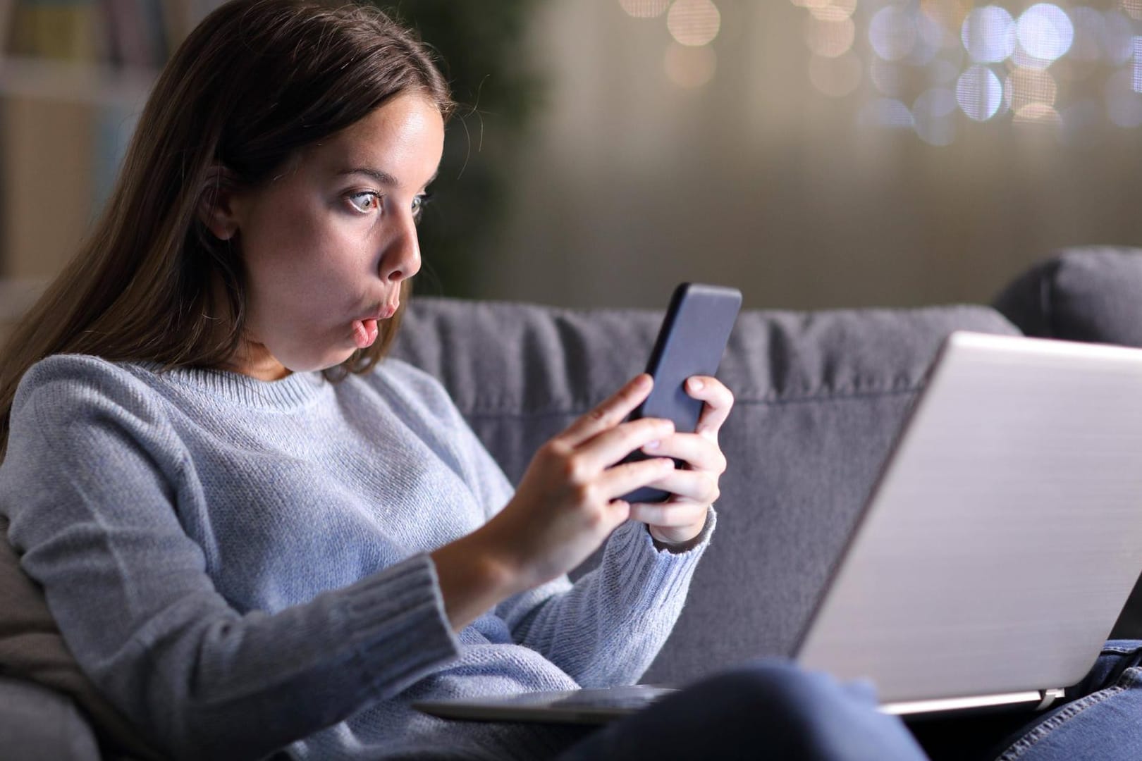 Frau starrt beeindruckt aufs Smartphone: Mit Wi-Fi 6E könnte das WLAN erheblich schneller werden