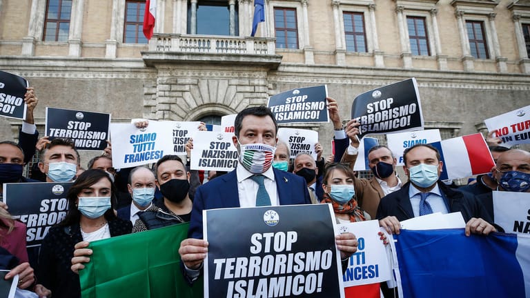 Italien, Rom: Matteo Salvini, Vorsitzender der Lega, hält ein Schild mit der Aufschrift "Stoppt den islamischen Terror" während eines Protestes vor der französischen Botschaft.