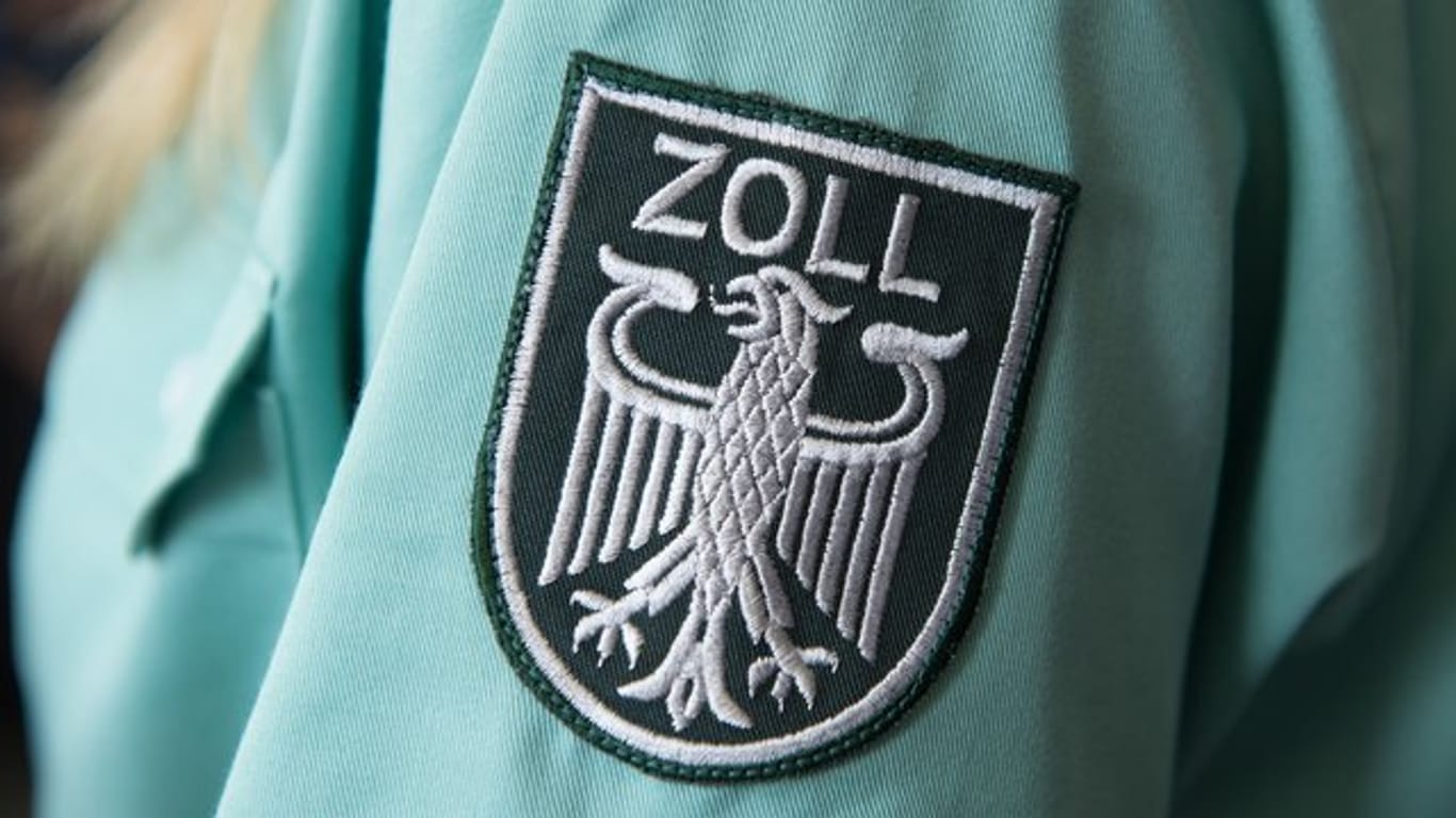 Wappenschild auf der Uniform einer Zollbeamtin (Symbolbild): In München versuchte ein Brite drei Kilo Koks zu schmuggeln.