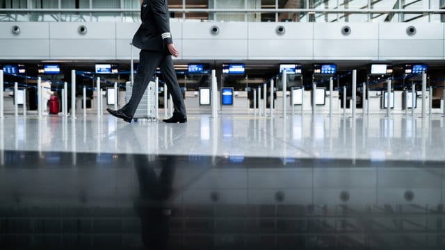 Ein Mann in Uniform geht am Check-In Bereich des Düsseldorfer Flughafens vorbei: Die Corona-Krise macht dem Airport schwer zu schaffen. Ein Mann in Uniform geht am Check-In Bereich des Düsseldorfer Flughafens vorbei: Die Corona-Krise macht dem Airport schwer zu schaffen.