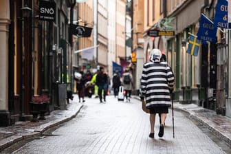 Eine ältere Frau läuft durch die Altstadt von Stochkolm: Derzeit steigen die Zahlen der Neuinfektionen wieder, auch in der Hauptstadt.