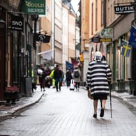 Eine ältere Frau läuft durch die Altstadt von Stochkolm: Derzeit steigen die Zahlen der Neuinfektionen wieder, auch in der Hauptstadt.