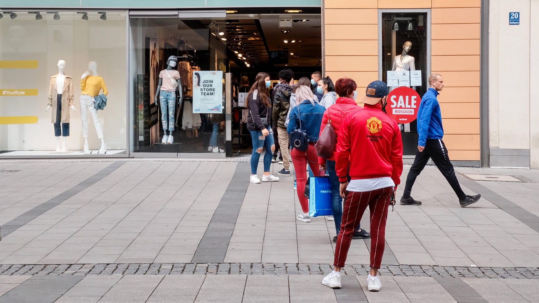 Menschen warten vor einem Laden (Symbolbild): Geschäfte sollen im Teil-Lockdown offen bleiben.