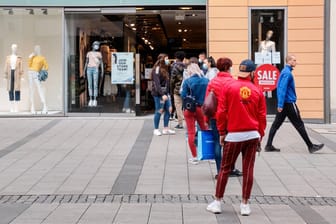 Menschen warten vor einem Laden (Symbolbild): Geschäfte sollen im Teil-Lockdown offen bleiben.