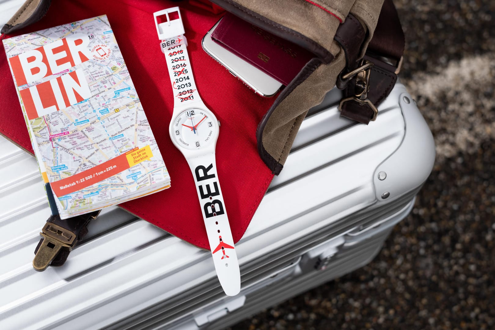 Eine Uhr liegt neben einem Berlin-Stadtplan: Der Uhrenhersteller Swatch bringt zur BER-Eröffnung eine Sonderedition heraus.