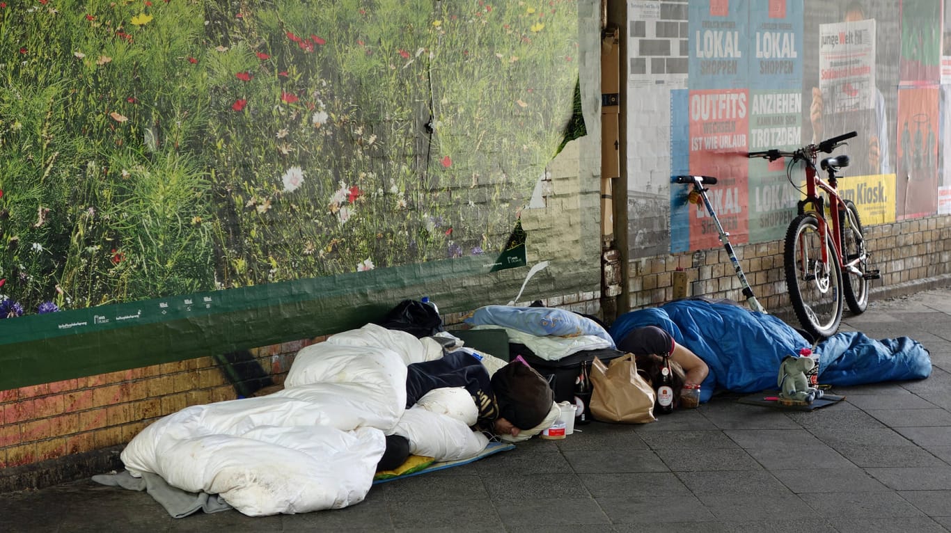 Menschen ohne festen Wohnsitz schlafen auf einer Straße in Berlin (Archivbild): In Charlottenburg hatte es eine Brandattacke auf einen Obdachlosen gegeben. Nun ist ein Mann festgenommen worden.