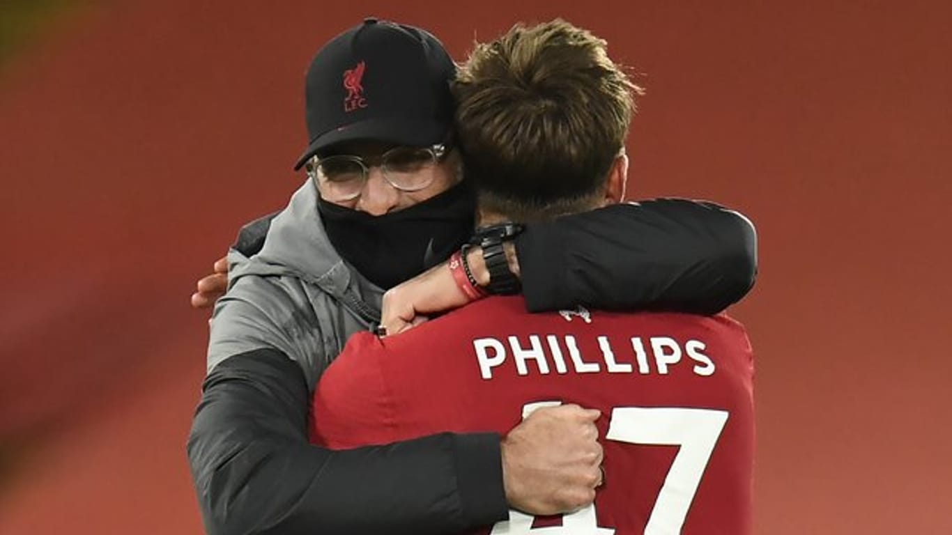 Liverpools Coach Jürgen Klopp umarmt nach dem Spiel Nathaniel Phillips.