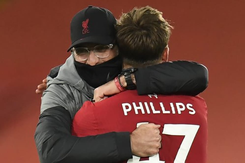 Liverpools Coach Jürgen Klopp umarmt nach dem Spiel Nathaniel Phillips.