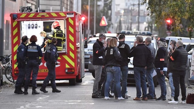 Rettungskräfte und Beamte der Polizei stehen am Tatort, an dem ein griechisch-orthodoxer Priester angeschossen wurde. Rettungskräfte und Beamte der Polizei stehen am Tatort, an dem ein griechisch-orthodoxer Priester angeschossen wurde.