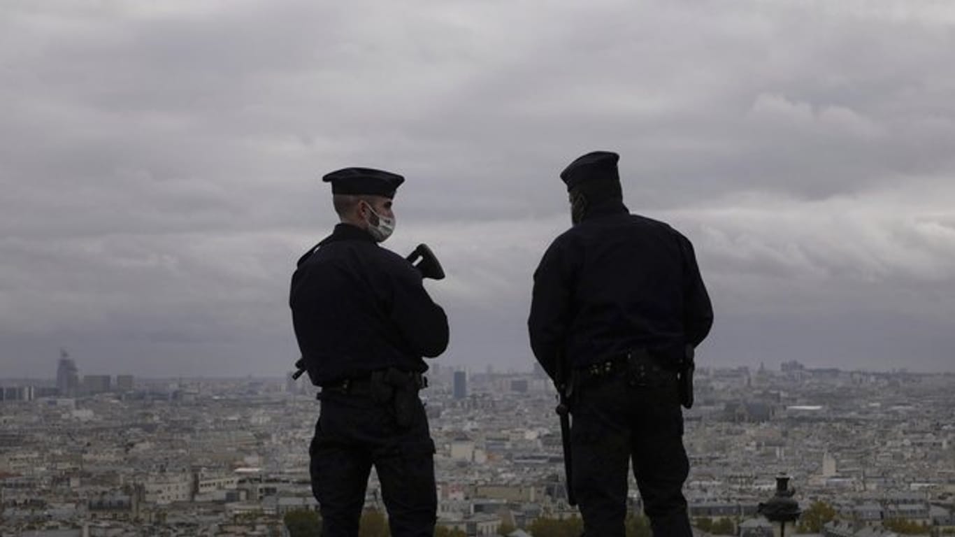 Zwei Polizeibeamte stehen auf dem Vorplatz der Basilika Sacré-Coeur in Paris Wache.