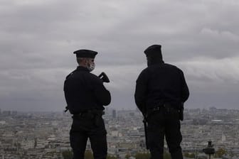 Zwei Polizeibeamte stehen auf dem Vorplatz der Basilika Sacré-Coeur in Paris Wache.