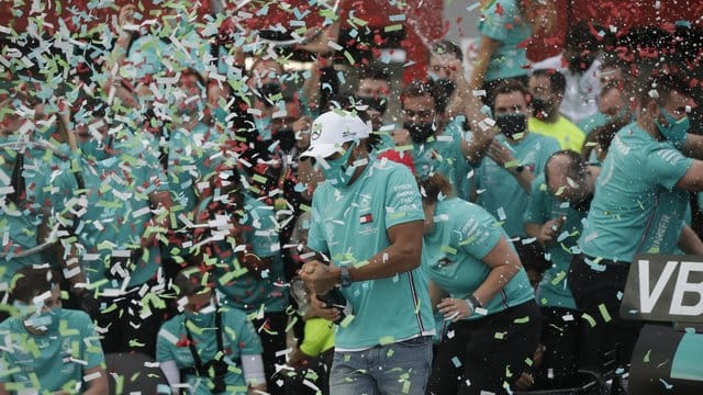 Lewis Hamilton (M) feiert mit seinem Team Mercedes in der Boxengasse seinen Sieg. Lewis Hamilton (M) feiert mit seinem Team Mercedes in der Boxengasse seinen Sieg.