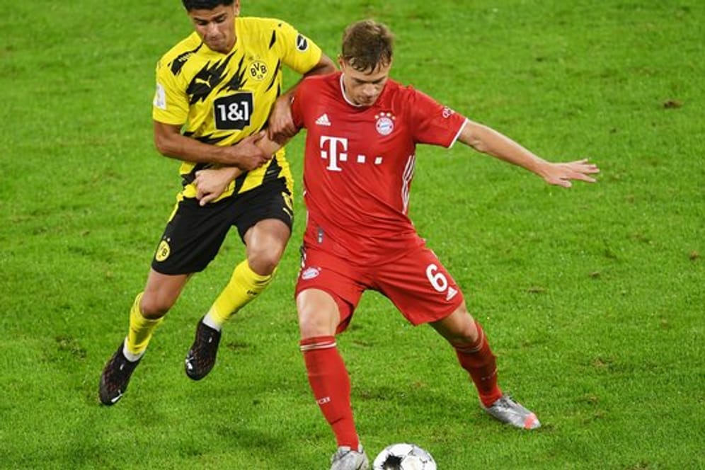 Dortmunds Mahmoud Dahoud (l) versucht Bayerns Joshua Kimmich den Ball abzunehmen.