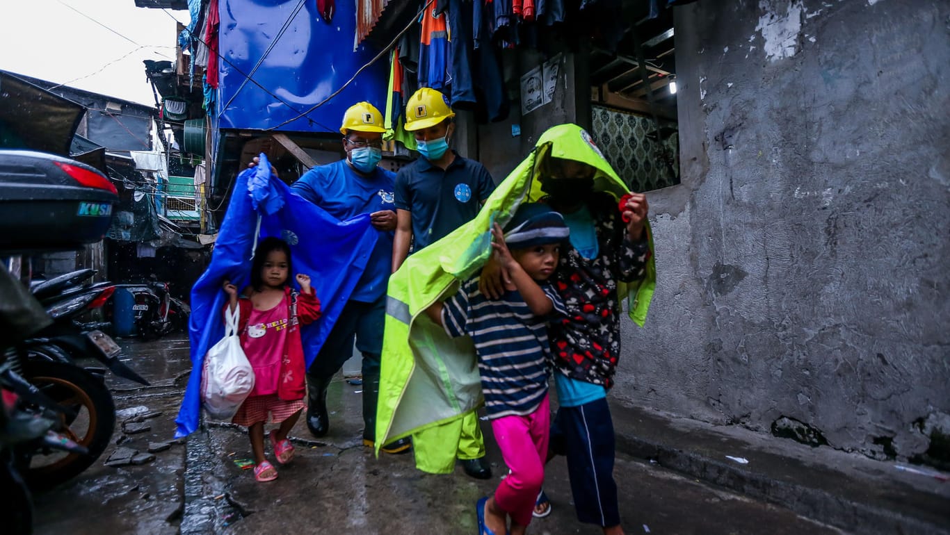Philippinen, Manila: Helfer bringen die Bewohner einer Küstenregion vor dem heftigen Regen und Wind in Sicherheit.