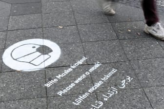 Am Gehweg ermahnt ein Graffiti zum Tagen einer Mund-Nasen-Bedeckung (Symbolbild): In Kiel herrscht nun auf verschiedenen Straßen und Plätzen eine Maskenpflicht.