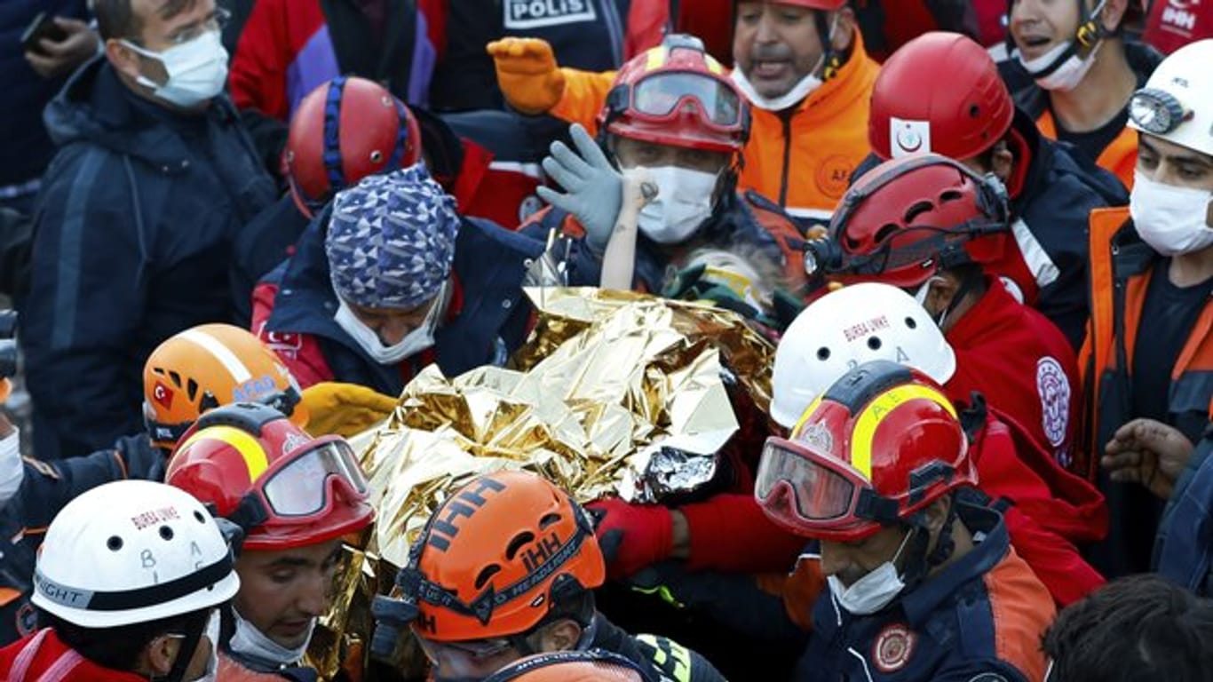 Rettungshelfer tragen die gerettete Dreijährige in Izmir aus den Trümmern.
