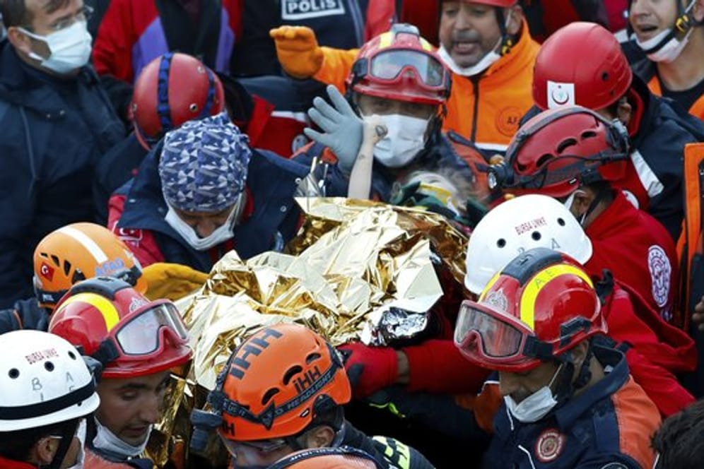 Rettungshelfer tragen die gerettete Dreijährige in Izmir aus den Trümmern.
