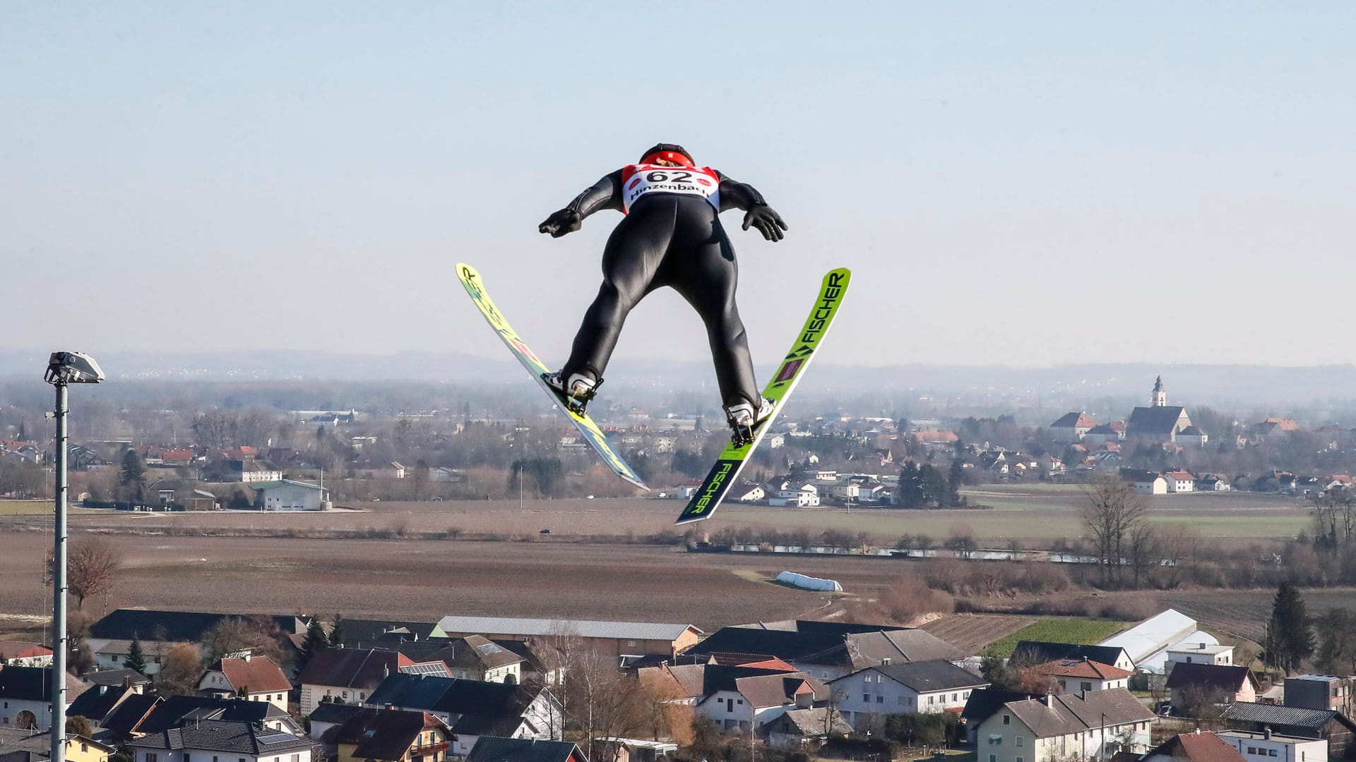 Katharina Althaus in der Luft. Im Hintergrund sind Häuser zu sehen: In Pyeongchang gewann die Skispringerin die Silber-Medaille.